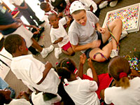 Katy making necklaces + bracelets with the kids.
