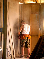 Justin drilling away an uneven concrete wall.